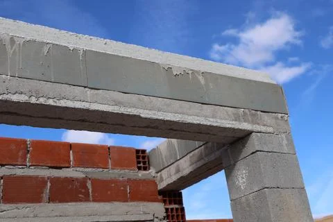 Construction of a doorway with concrete blocks and red bricks against a blu.. Stock Photos
