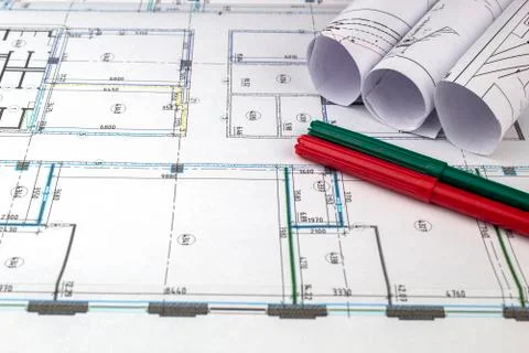 Construction drawings rolled into a roll, markers of green and red color lie  Stock Photos