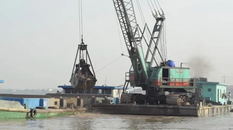 CONSTRUCTION DREDGING: Crane scoops sand from river in giant bucket Video stock 35734223