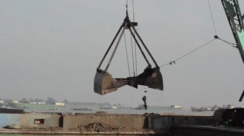 CONSTRUCTION DREDGING: Giant shovel pulls sand from river, drops again Video stock 35734839