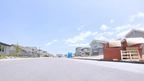 Construction dumpster and materials on street Stock Photos