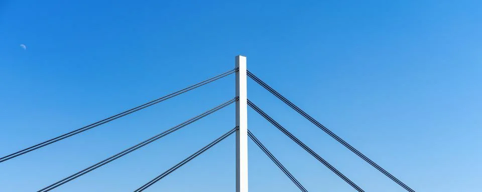 Construction elements of pylon cable-stayed bridge in front of blue sky. Stock Photos