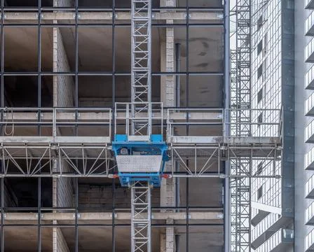 Construction elevator and mast climbing work platform on a modern building Stock Photos