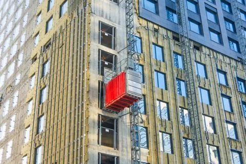 Construction elevator outside the facade of a multi-storey building under con Foto stock