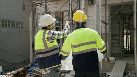 Construction engineer and foreman walking holding blueprints walking inspect Stock-Footage 226810540