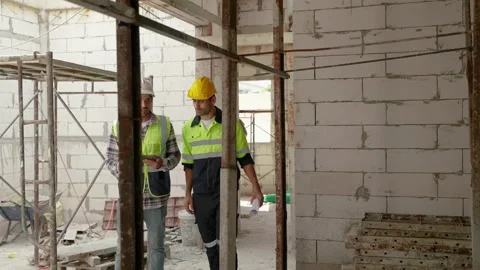 Construction engineer and foreman walking holding blueprints walking inspect Stock Footage 226811049