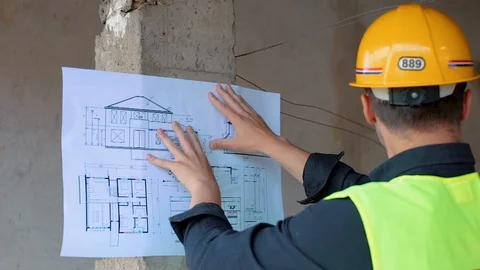Construction engineer architect holding office blueprints against pillar Stock Footage 129444926