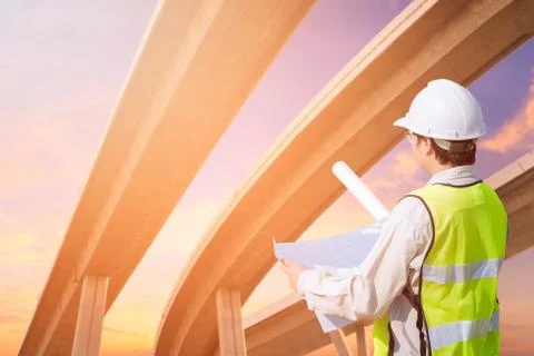 Construction engineer checking construction drawing with expressway Photos
