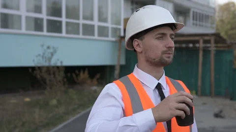 Construction engineer on a coffee break near the construction site of the house. Stock Footage 172008872