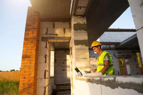 Construction engineer on the construction site of a house made of porous conc Stock Photos