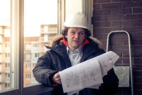 Construction engineer in hardhat with project in hands. Soft focus, toned. Stockfoto's