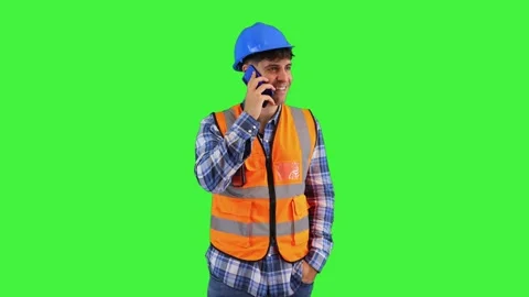 Construction engineer making a call on his smartphone, wearing orange vest .. Stock Footage 286986172