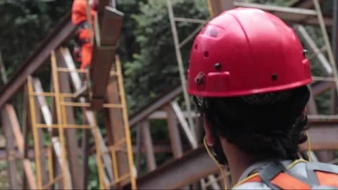 Construction engineer supervising metal workers building steel frame structure Stock Footage 255684427