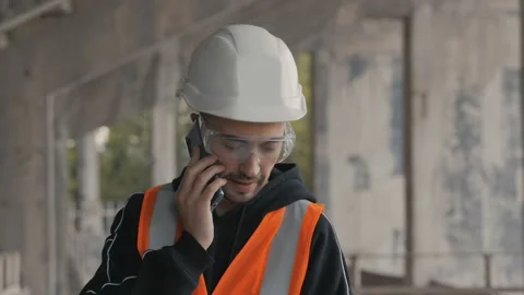 Construction engineer talking on the phone in a building under construction Stock Footage 132490336