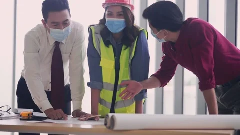 Construction Engineer team is brainstorming while wearing protective mask in pan Stock Footage 148377266