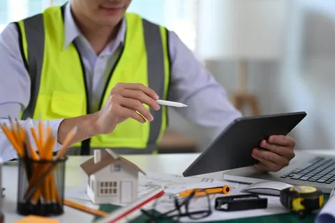 Construction engineer using digital tablet while sitting at workplace Foto stock