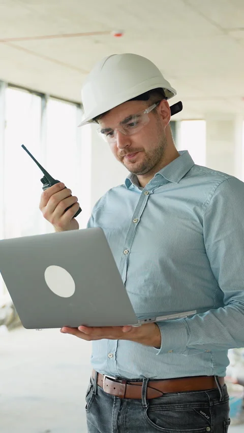 Construction Engineer Using Laptop and Radio on Job Site Stock Footage 285683661