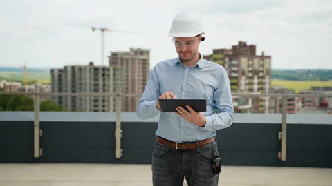 Construction engineer using tablet for project management on rooftop site Stock Footage 285670306