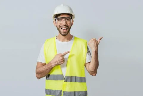 Construction engineer with vest pointing at an advertisement. Engineer man .. Stock Photos