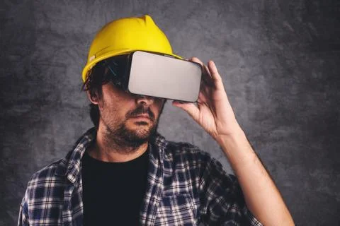 Construction engineer with VR goggles managing building project Stock Photos