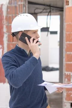 Construction engineer wearing a protective hardhat and discussing project p.. 库存照片