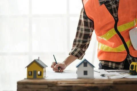 Construction engineer working at blueprint to build a home. Stock Photos