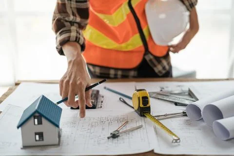 Construction engineer working at blueprint to build a home. Stock Photos