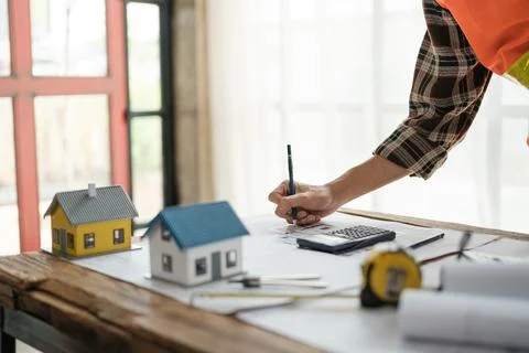 Construction engineer working at blueprint to build a home. Stock Photos