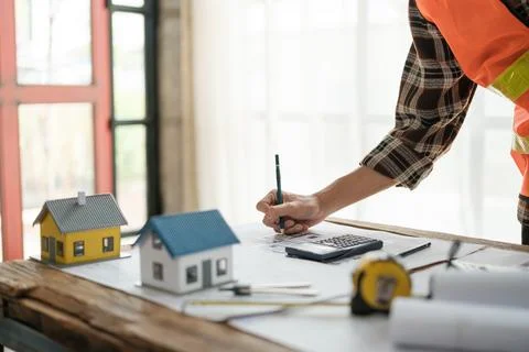 Construction engineer working at blueprint to build a home. Stock Photos