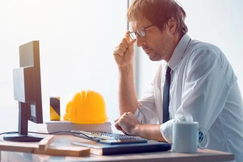 Construction engineer working on desktop computer using CAD soft Stock Photos