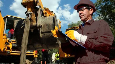 Construction Engineer Writing on Clipboard at Construction Site Foto stock