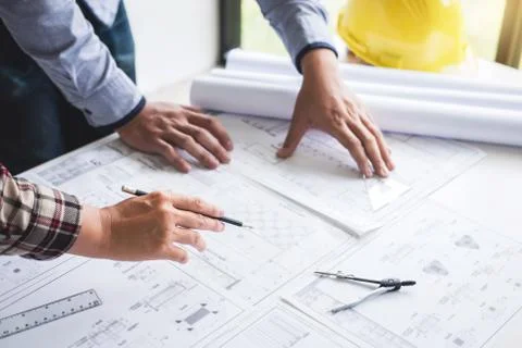 Construction engineering or architect discuss a blueprint while checking info Stock Photos