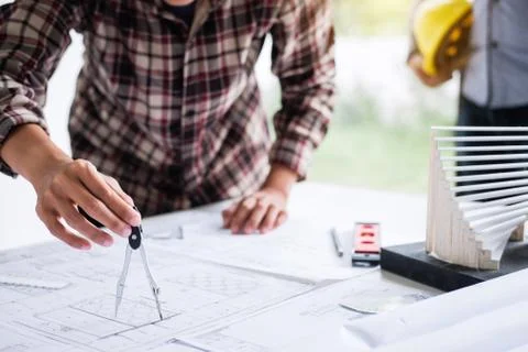 Construction engineering or architect discuss a blueprint while checking info Stock Photos