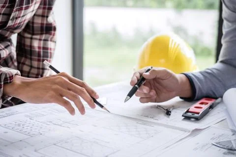 Construction engineering or architect discuss a blueprint while checking info Stock Photos