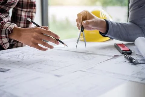 Construction engineering or architect discuss a blueprint while checking info Stock Photos