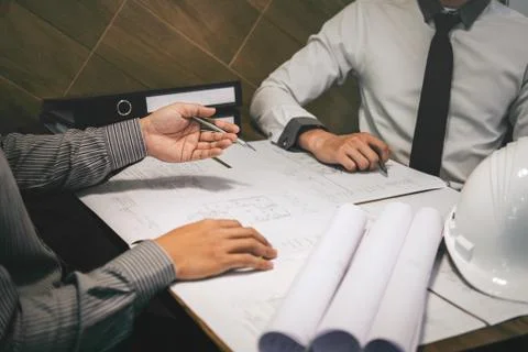 Construction engineering or architect discuss a blueprint while checking info Stock Photos