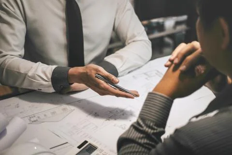 Construction engineering or architect discuss a blueprint while checking info Stock Photos