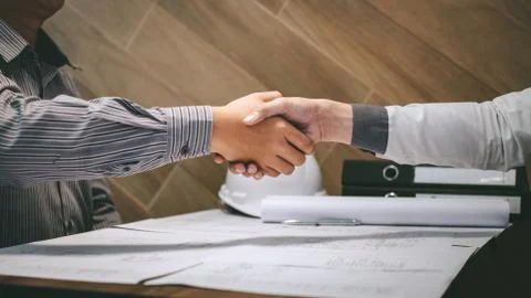 Construction engineering or architect discuss a blueprint while checking info Stock Photos
