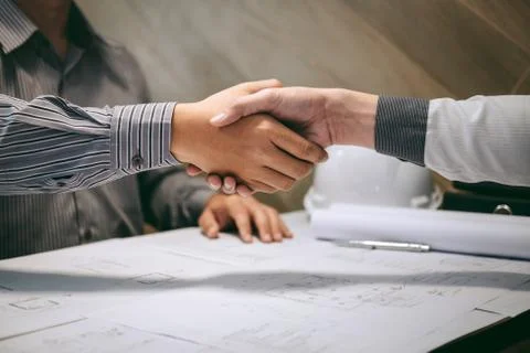 Construction engineering or architect discuss a blueprint while checking info Stock Photos