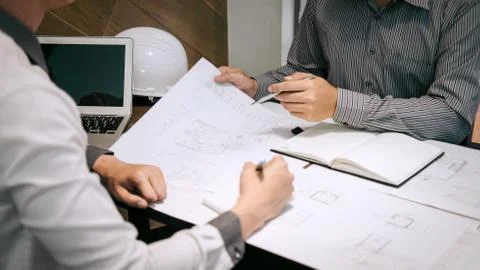 Construction engineering or architect discuss a blueprint while checking info Stock Photos