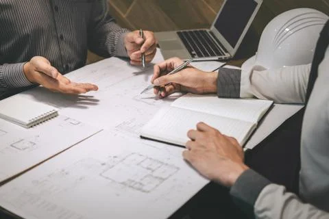 Construction engineering or architect discuss a blueprint while checking info Stock Photos