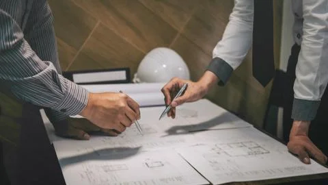 Construction engineering or architect discuss a blueprint while checking info Stock Photos