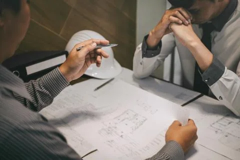 Construction engineering or architect discuss a blueprint while checking info Stock Photos