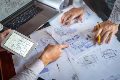 Construction engineering or architect discuss a blueprint while checking info Stock Photos