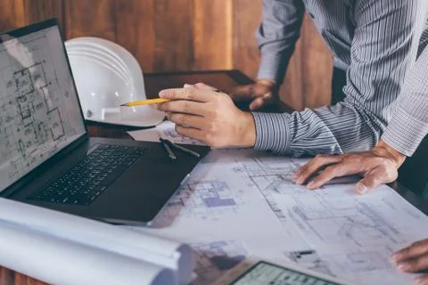 Construction engineering or architect discuss a blueprint while checking info Stock Photos