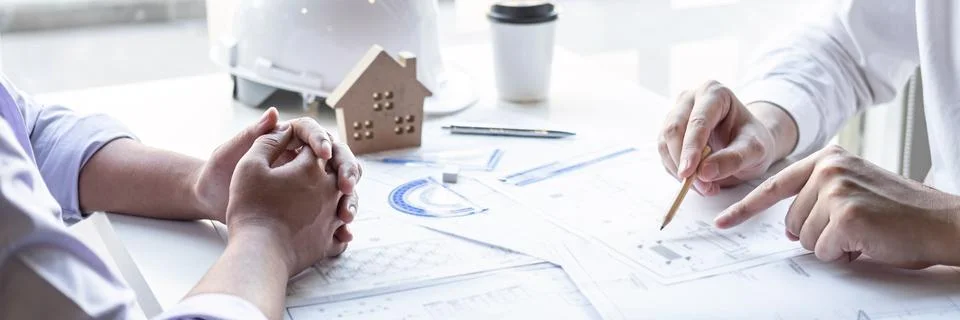Construction engineering or architect discuss a blueprint while checking info Stock Photos