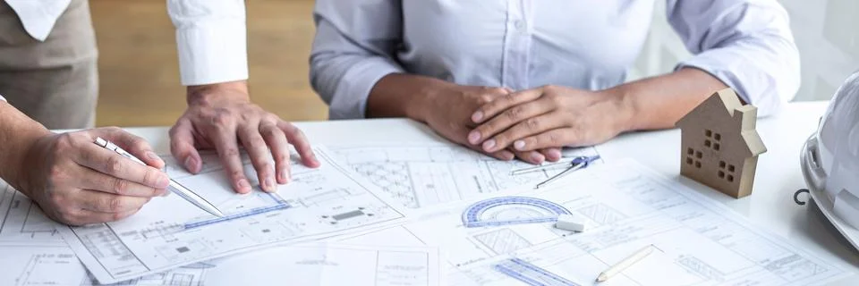 Construction engineering or architect discuss a blueprint while checking info Foto stock