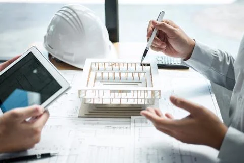 Construction engineering or architect discussing a blueprint and building mod Stock Photos