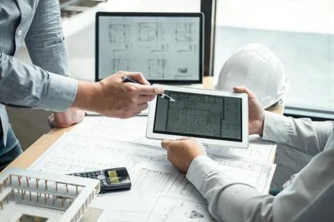 Construction engineering or architect discussing a blueprint and building mod Stock Photos