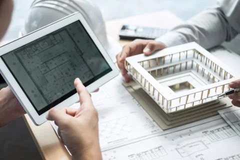 Construction engineering or architect discussing a blueprint and building mod Stock Photos